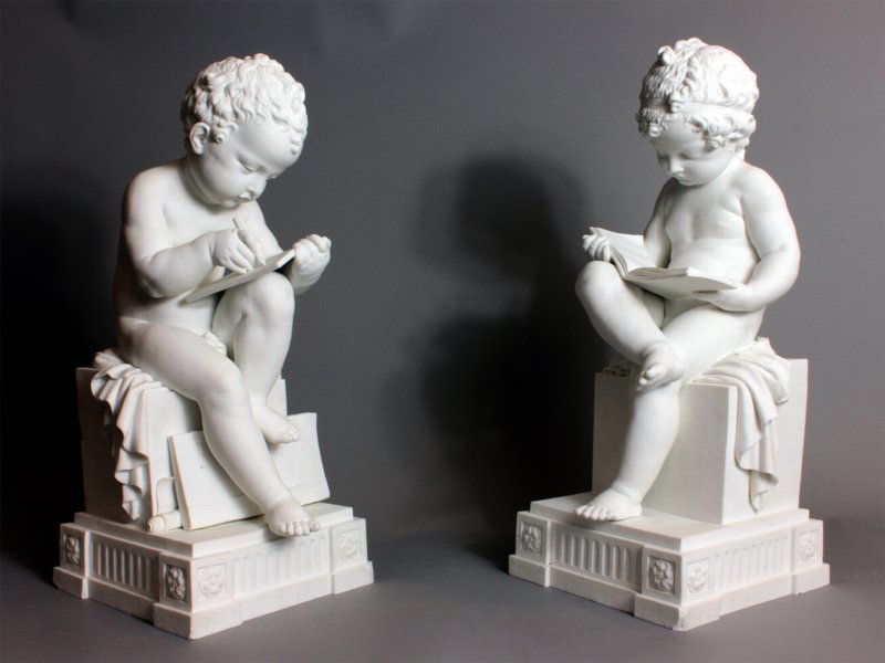 Dihl and Gurard biscuit figures depicting a boy reading and a girl writing.